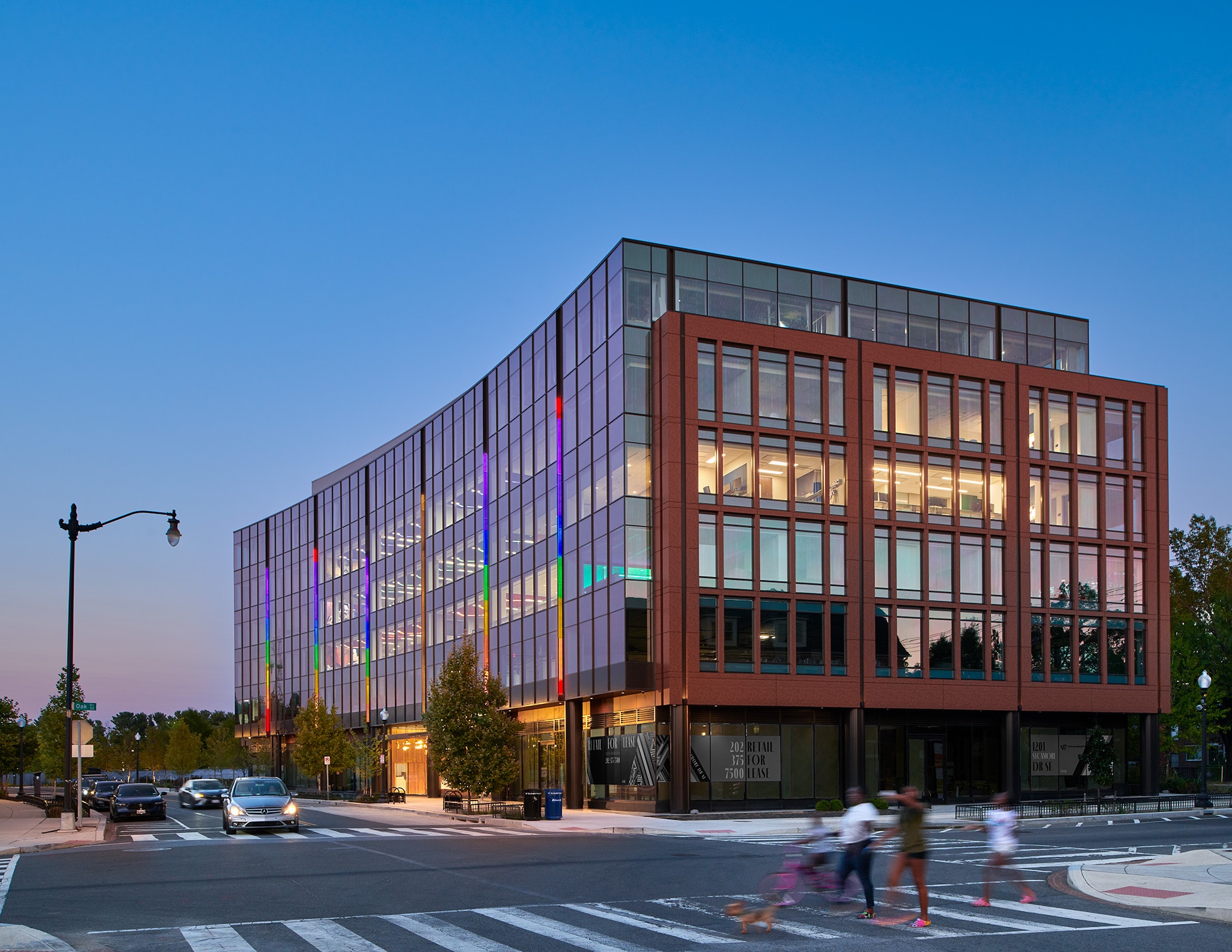 Luxury multifamily building at dusk with rooftop pool